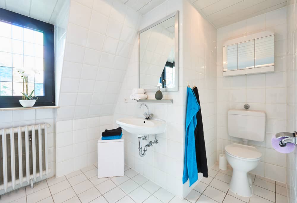 4-Raum-Appartement App073 Bad WC Schrank Waschbecken Spiegel Mosaikfenster weiße Fliesen