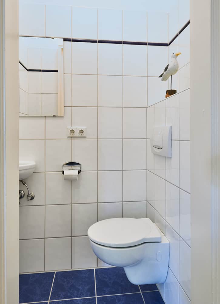 3-Zimmer-Wohnung App501 Badezimmer 2 WC Waschbecken Spiegel Blaue Bodenfliesen Weiße Fliesen