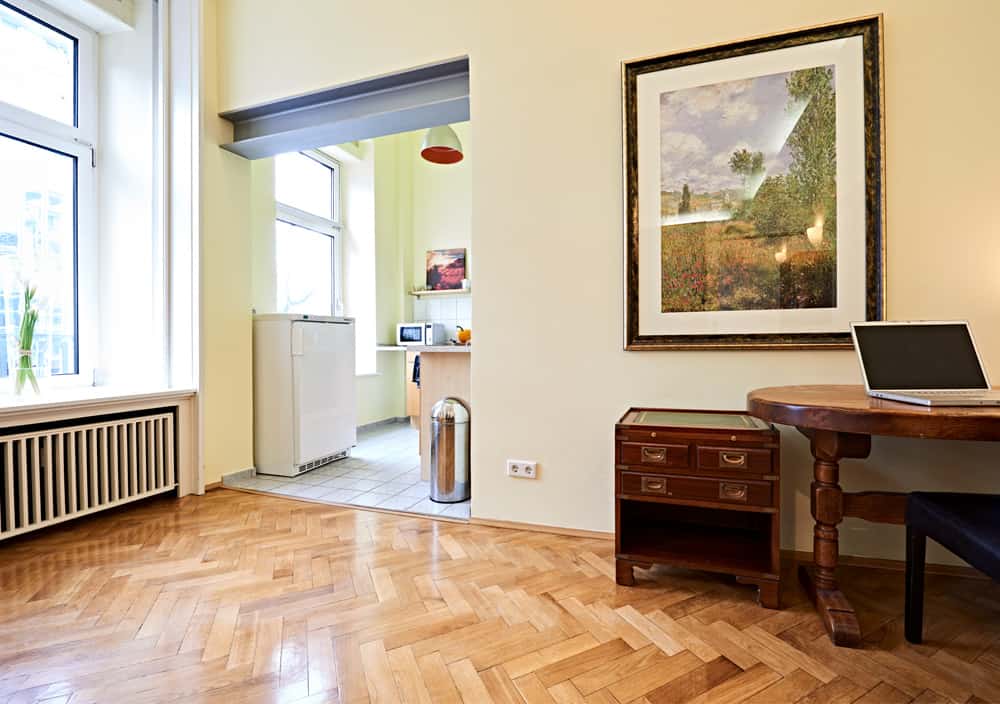 3-Raum-Appartement App501 Wohnbereich Schreibtisch Schrank Parkett Küche Theke Fliesen