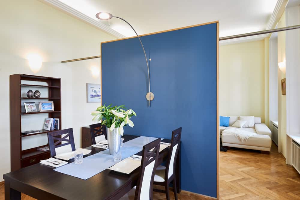 3-Raum-Appartement App501 Essbereich Tisch blauer Wandtrenner Parkett