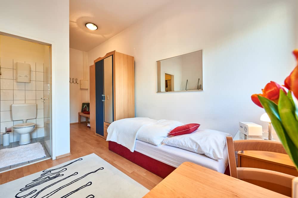 1-Raum-Appartement App524 Wohnbereich Essbereich Bett Nachttisch Spiegel Schrank Laminat